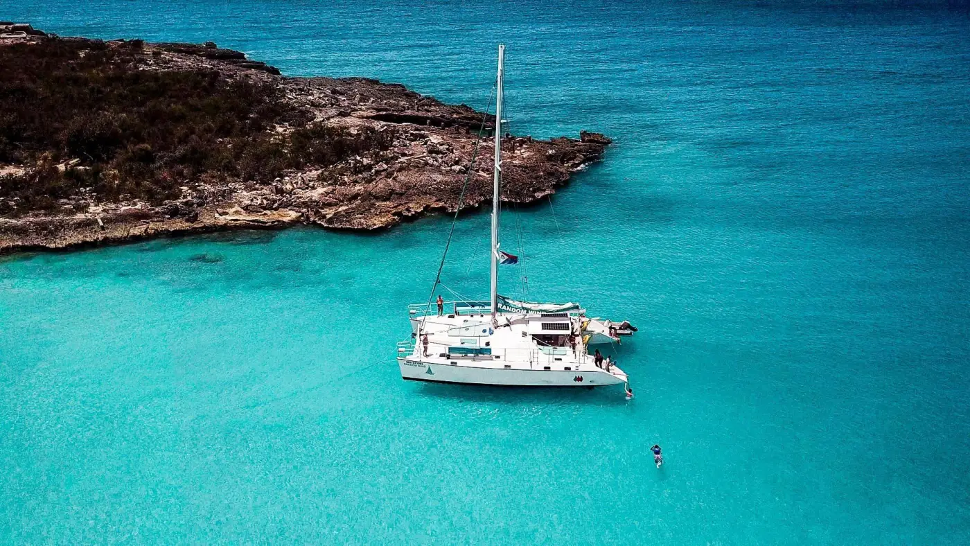 Catamaran Random Wind Charters ancre dans une eau turquoise a Sint Maarten