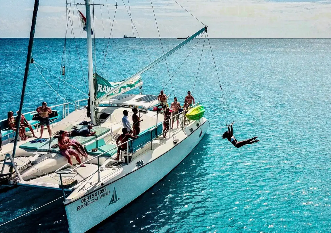 Passagers sur le catamaran Random Wind avec Tarzan swing au-dessus de la mer