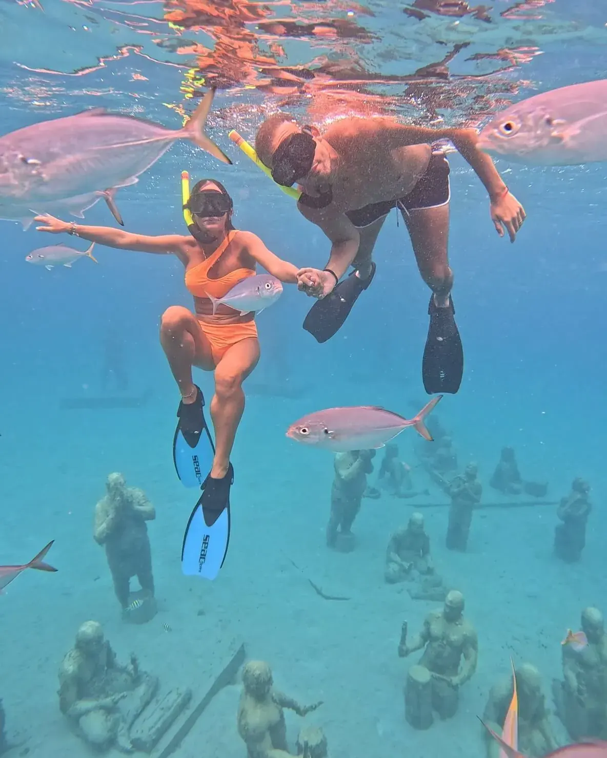 Couple en snorkeling au-dessus des sculptures taino du parc Under SXM