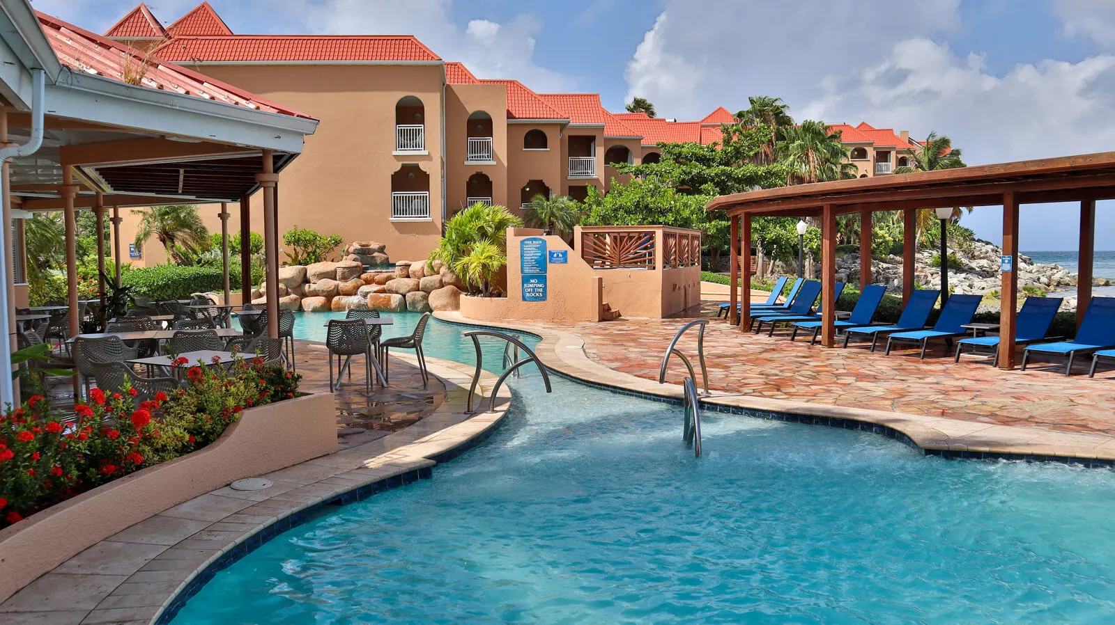 Pool deck et batiments aux toits rouges de Divi Little Bay