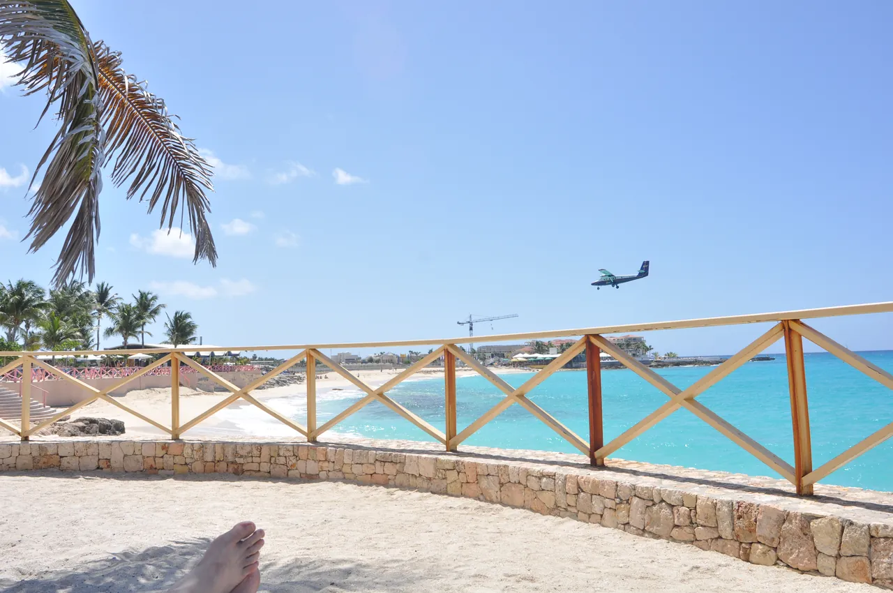 Petit avion en approche de l'aéroport Princess Juliana avec plage et eaux turquoise voisines
