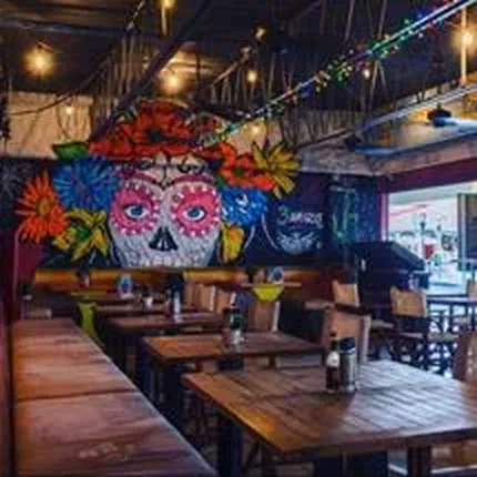 Salle à manger de 3 Amigos avec ses banquettes et la grande fresque Catrina au mur