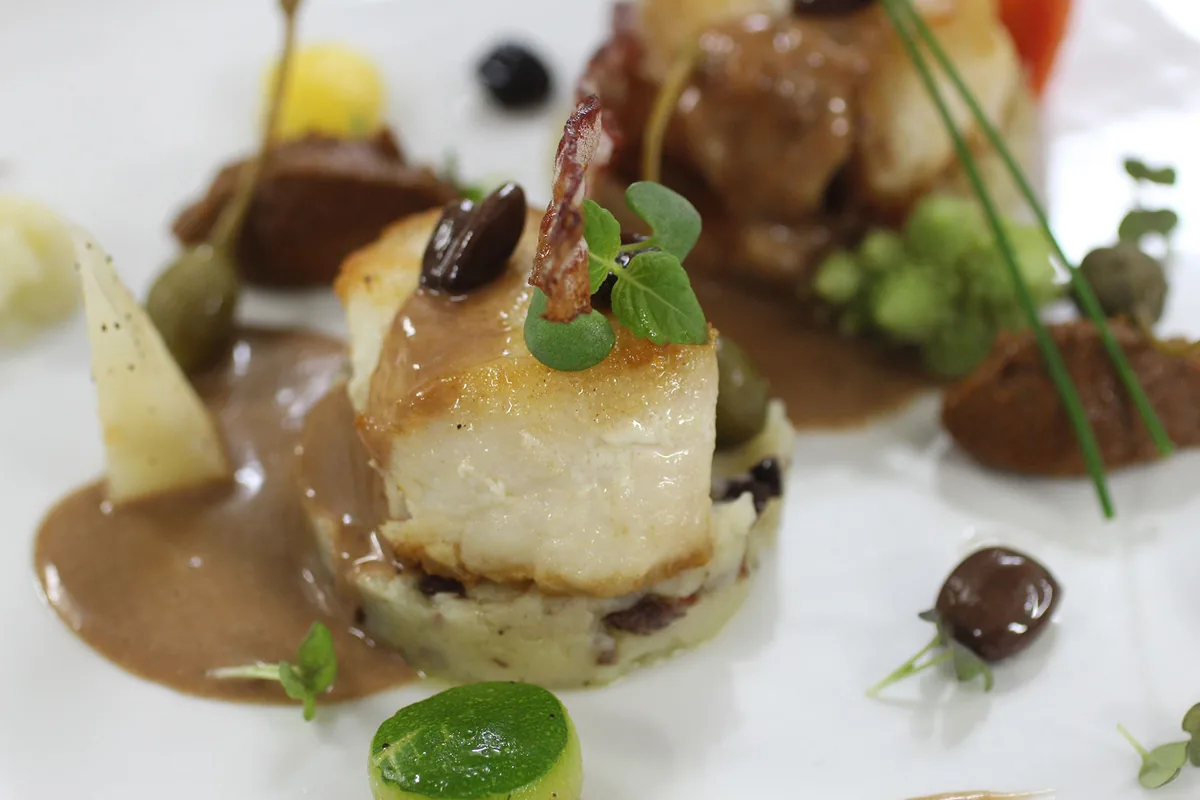 Filet de poisson nacré, sauce vin rouge et purée d'olives, dressage gastronomique à L'Astrolabe