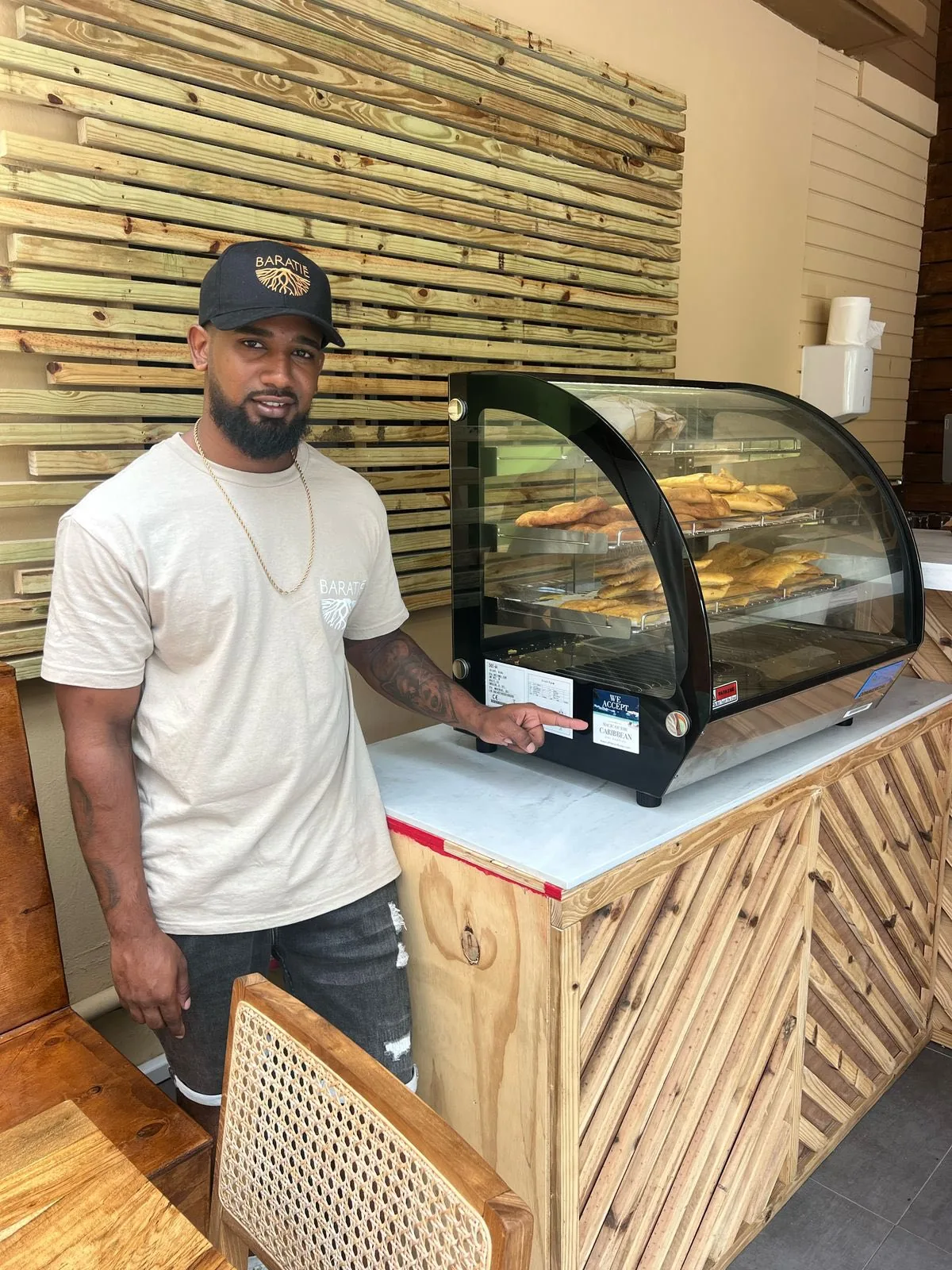 Le chef Shane Huggins, fondateur de Baratié SXM, devant la vitrine d'empanadas maison