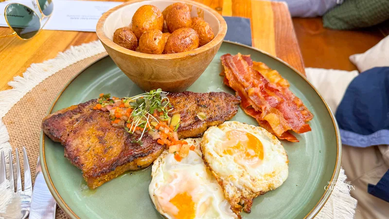 Assiette de petit-déjeuner Baratié SXM avec œufs, bacon, plantain et accras