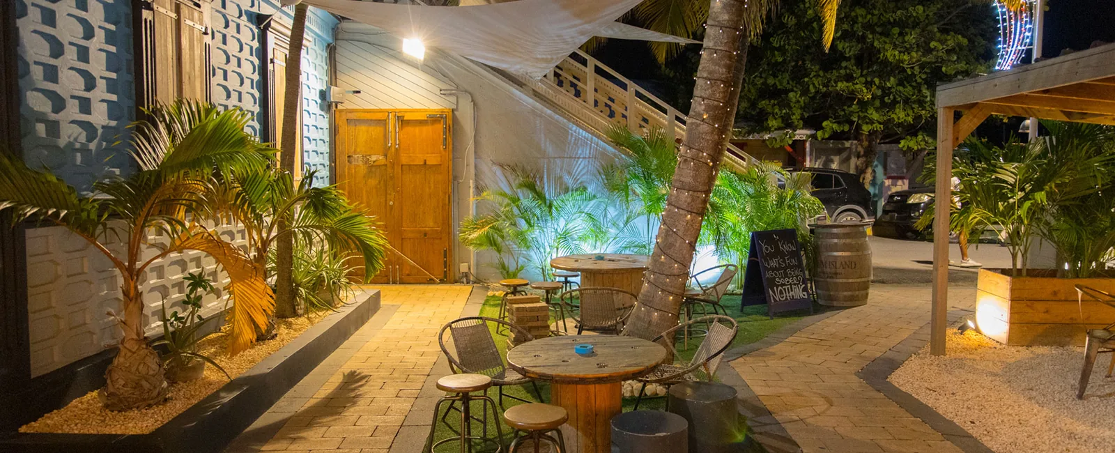 Façade éclairée du restaurant Blue Martini sur le boulevard de Grand Case avec terrasse en jardin tropical