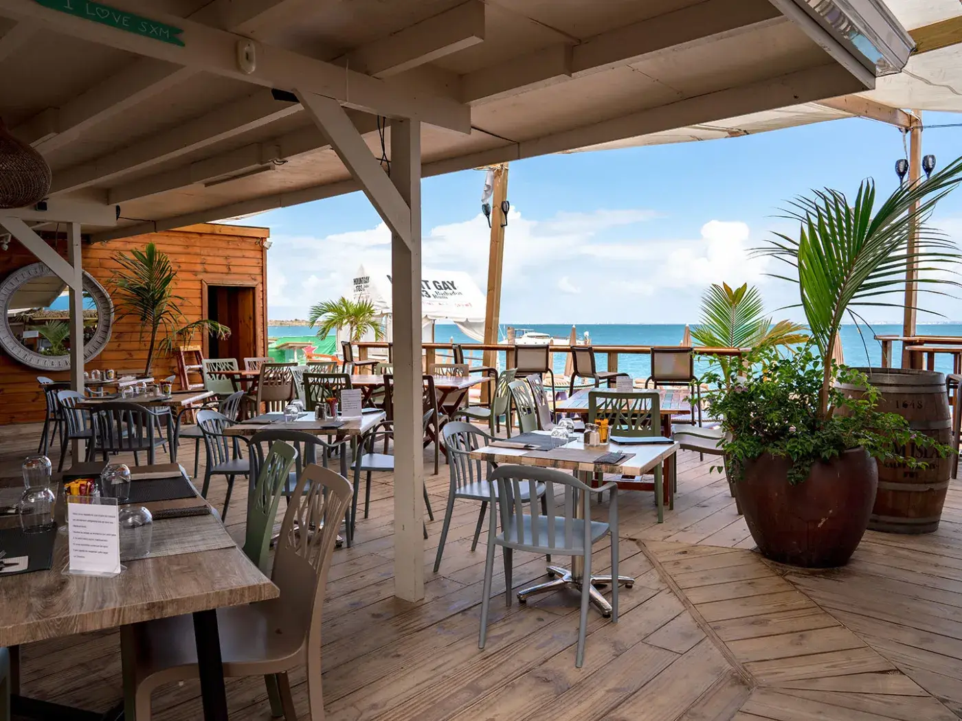 Captain Frenchy - terrasse en bois avec tables face à la mer de Grand Case