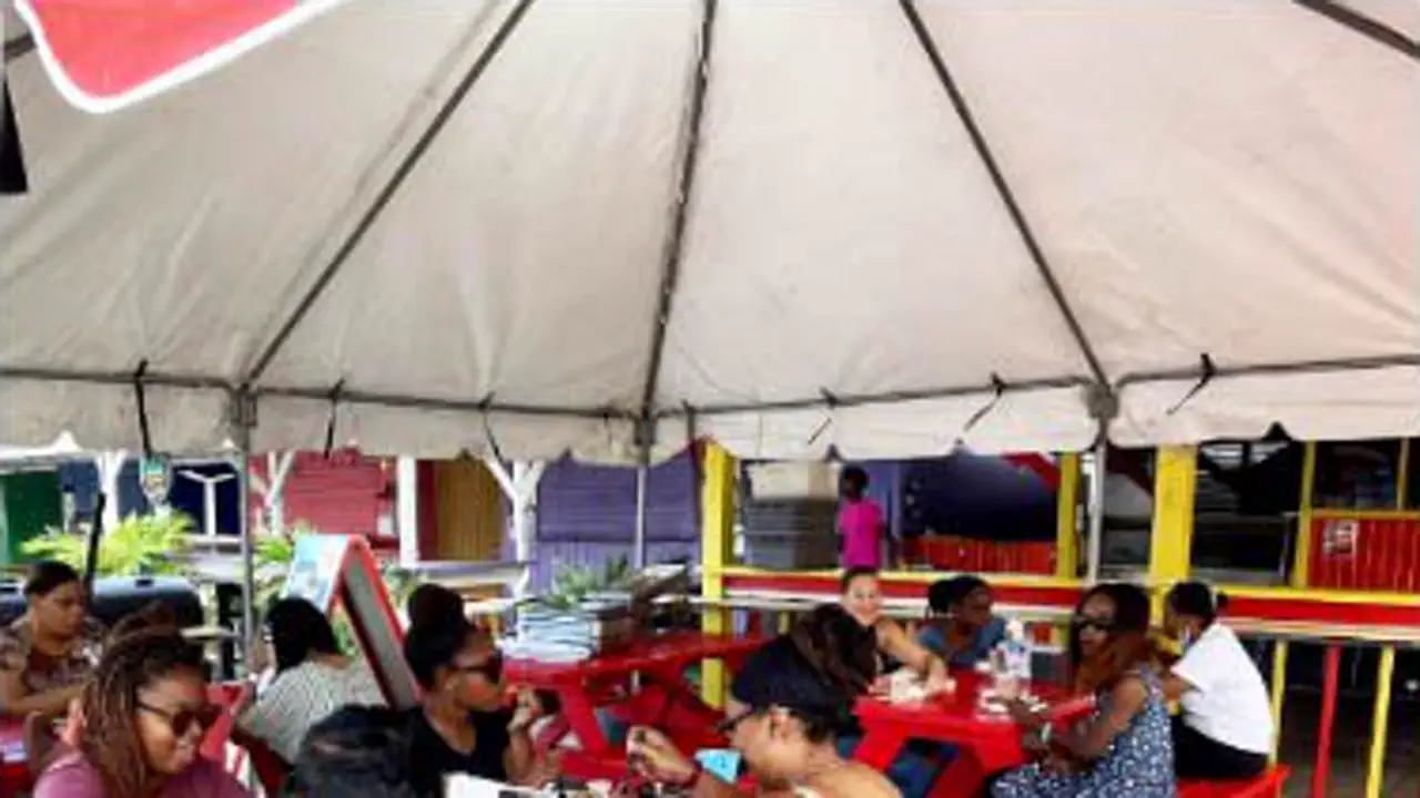 Captain’s Rib Shack - Tables rouges en plein air sous l’espace ombragé