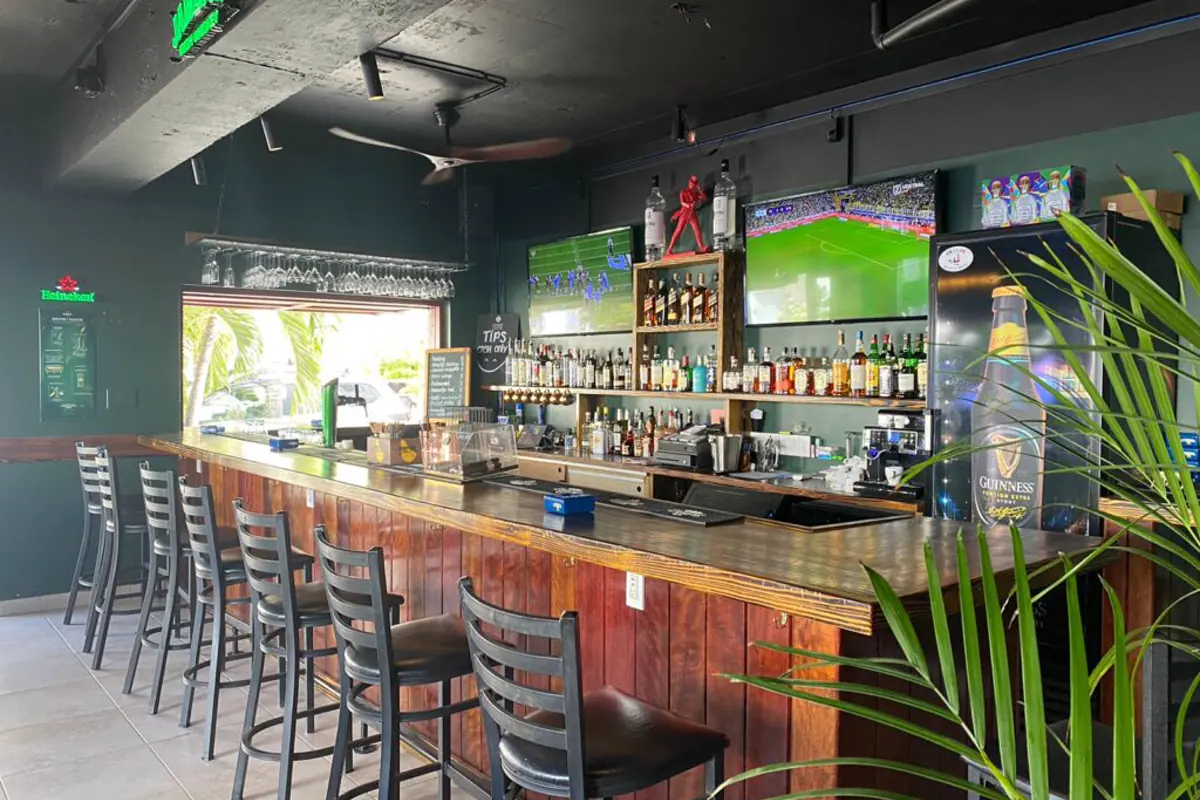 Comptoir interieur de Huppel The Pub avec ecrans sports et bar en bois