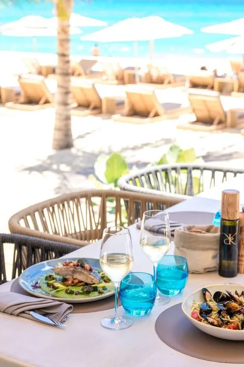 Entrée du restaurant Kalatua avec panneau bambou et logo corail à Cupecoy