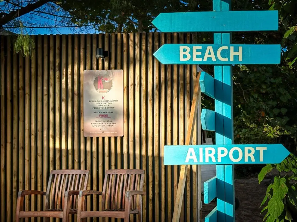 Karakter - panneau d'entrée du beach club entre plage et aéroport