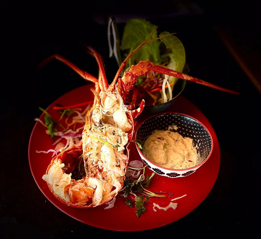 Demi-langouste grillée et sa sauce signature servies à Korner SXM Grand Case