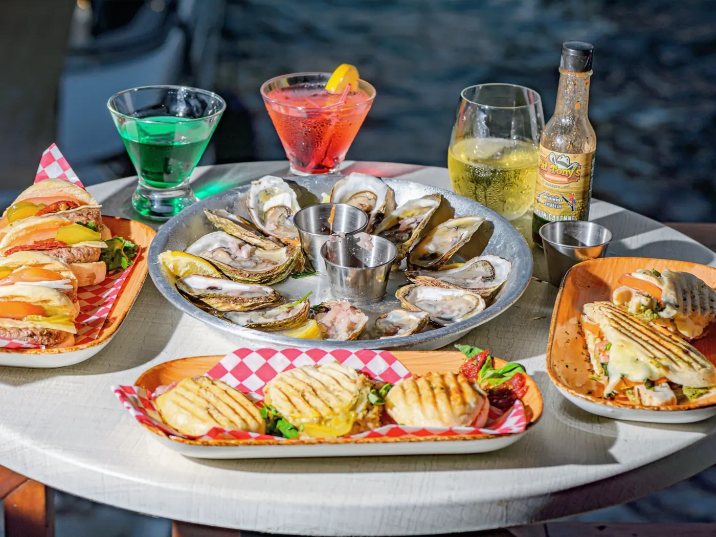 Kraken Raw Bar SXM - plateau d'huitres, paninis et cocktails sur une table