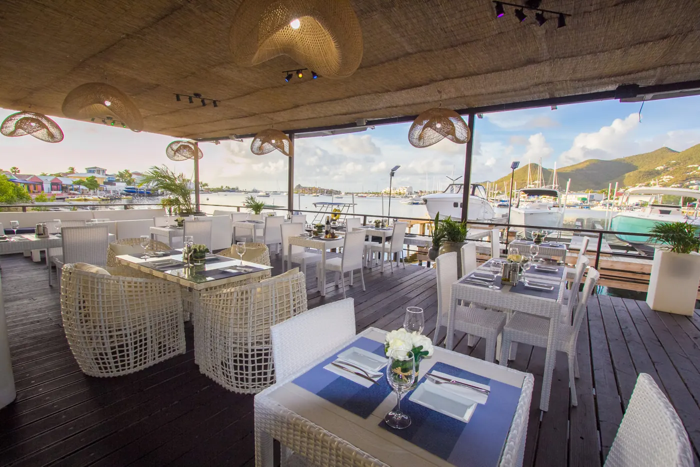Terrasse ouverte de La Perle Bleu avec tables face aux bateaux du lagon de Simpson Bay