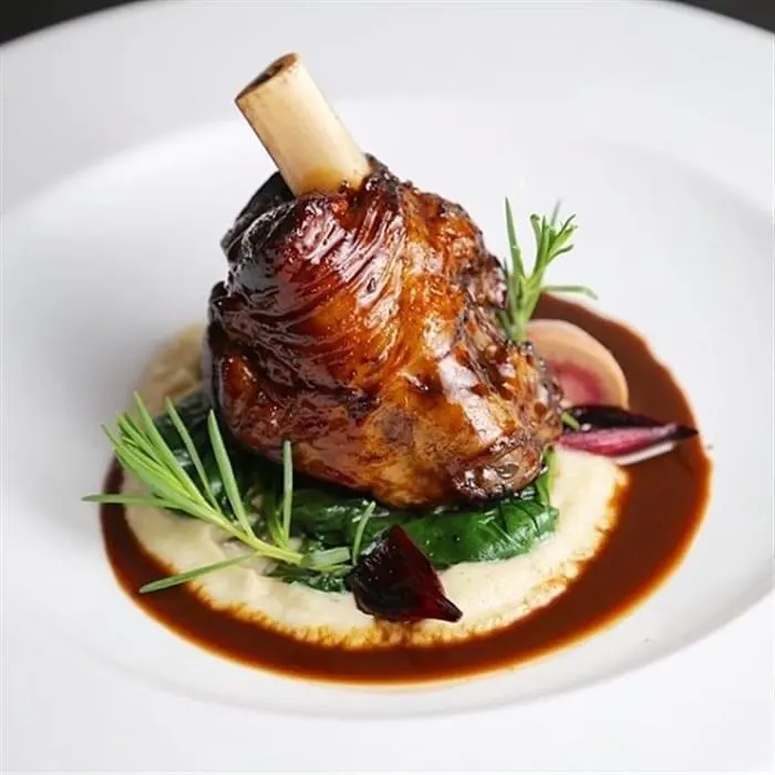 Agneau braisé au vin rouge servi avec purée et jus réduit à La Perle Bleu