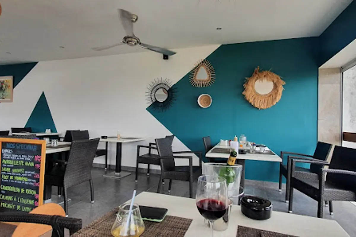 Salle ouverte du Grand St Martin avec tables et decor bleu a Marigot