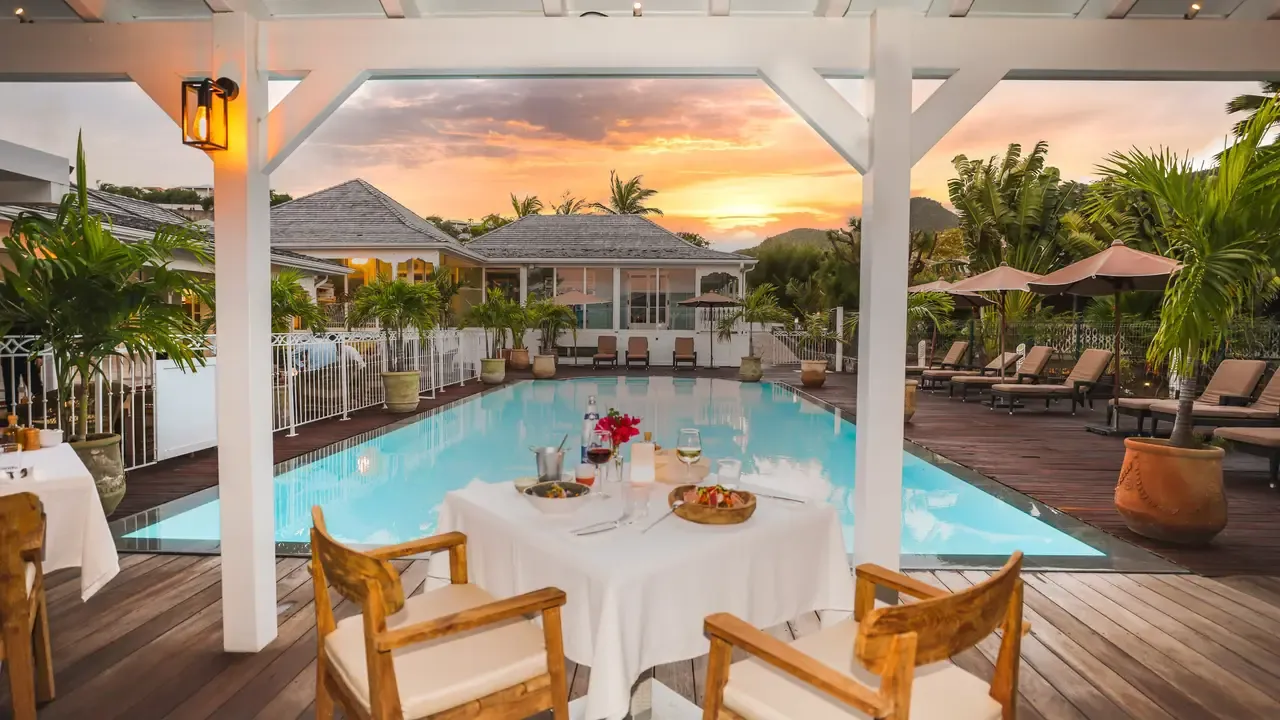 Table dressée au bord de la piscine du restaurant Le Sud au coucher du soleil