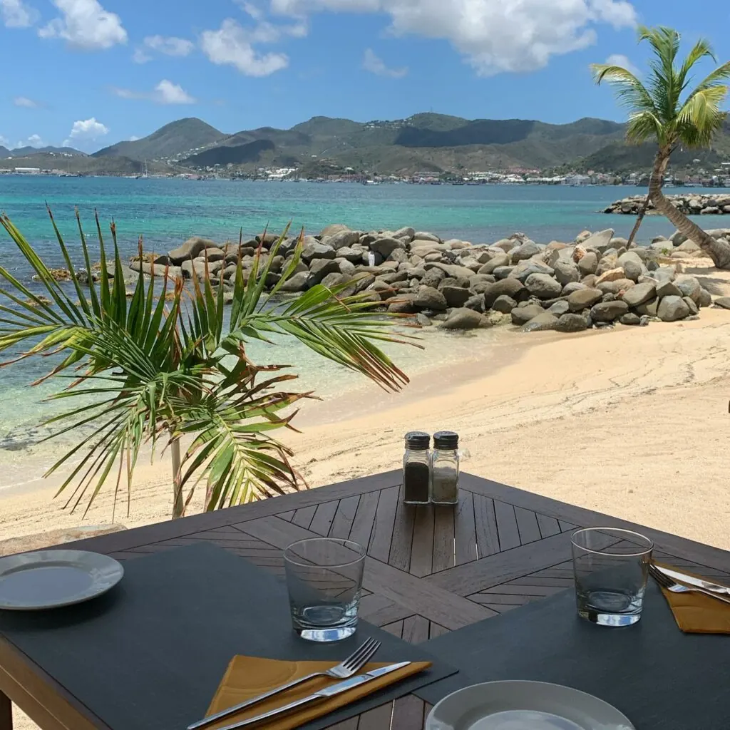 Table dressée de Mezza Luna avec vue sur la plage et la baie de Marigot