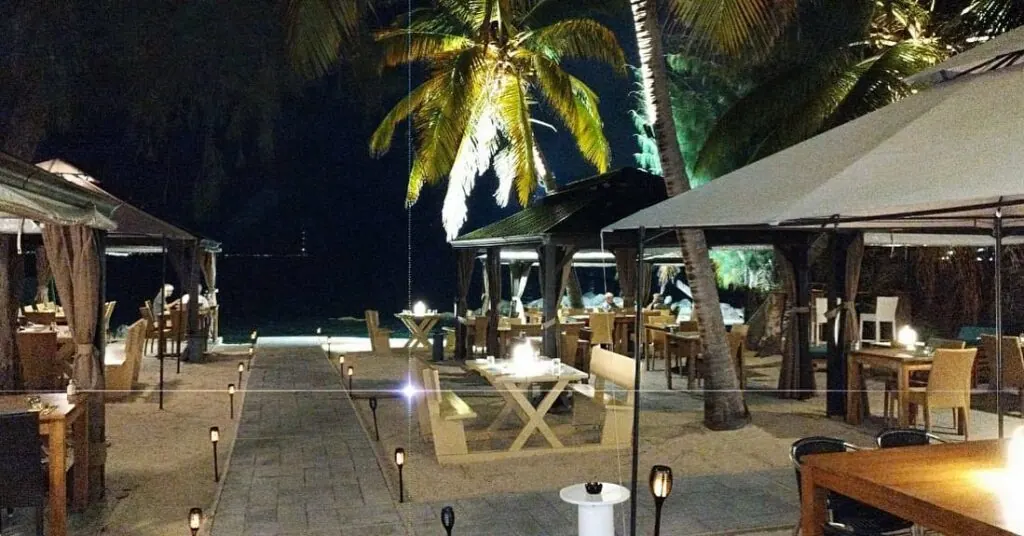 Terrasse de Mezza Luna de nuit avec tables éclairées au bord de la plage