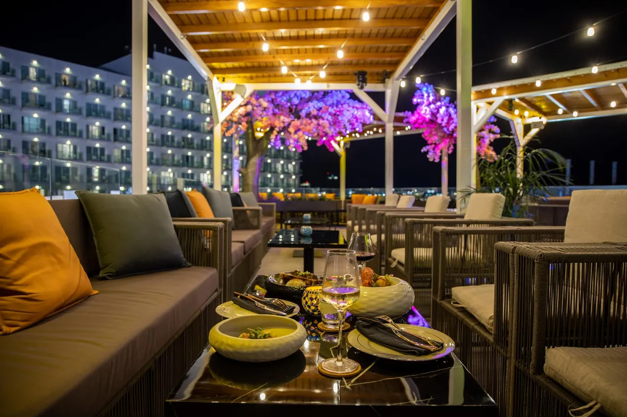Mise en bouche servie sur table basse au rooftop Mimosa Skylounge la nuit