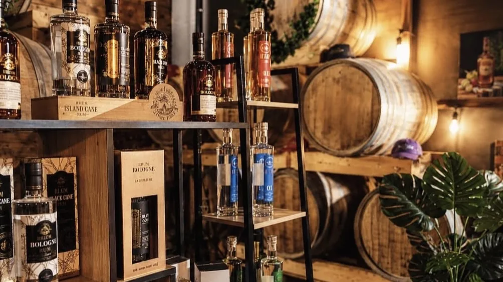 Oualichi Rhum - Étagères de rhums et fûts en bois dans la salle du bar