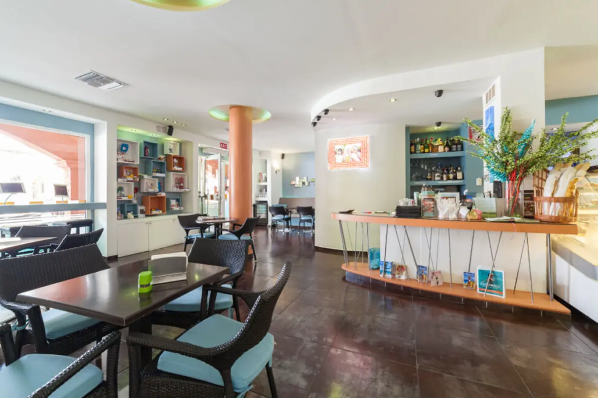 Salle interieure de Rendez Vous Lounge avec bar et tables de cafe a Cupecoy