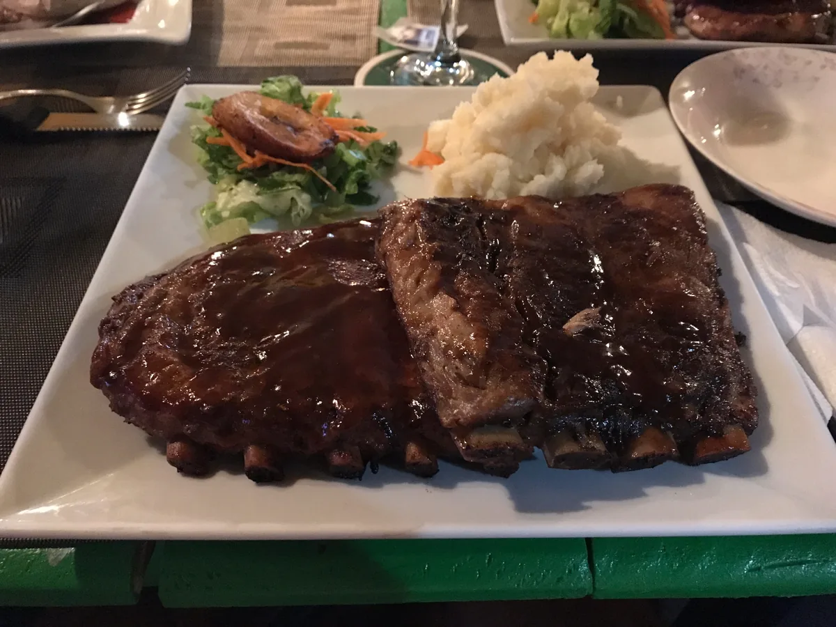Travers de porc Drunken Ribs glacés, signature de The Palms à Simpson Bay