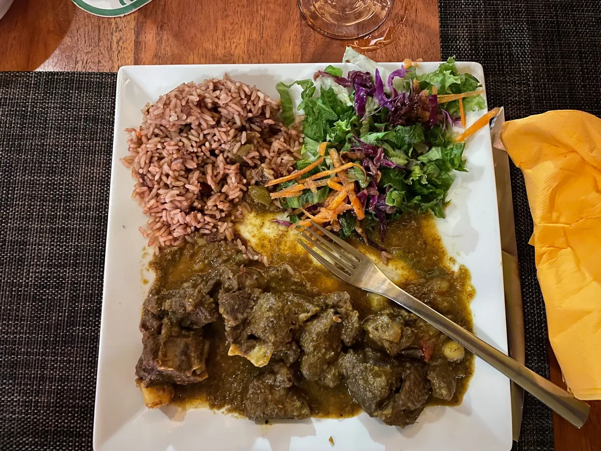 Goat curry façon Trinidad servi avec riz aux haricots rouges et salade à The Palms
