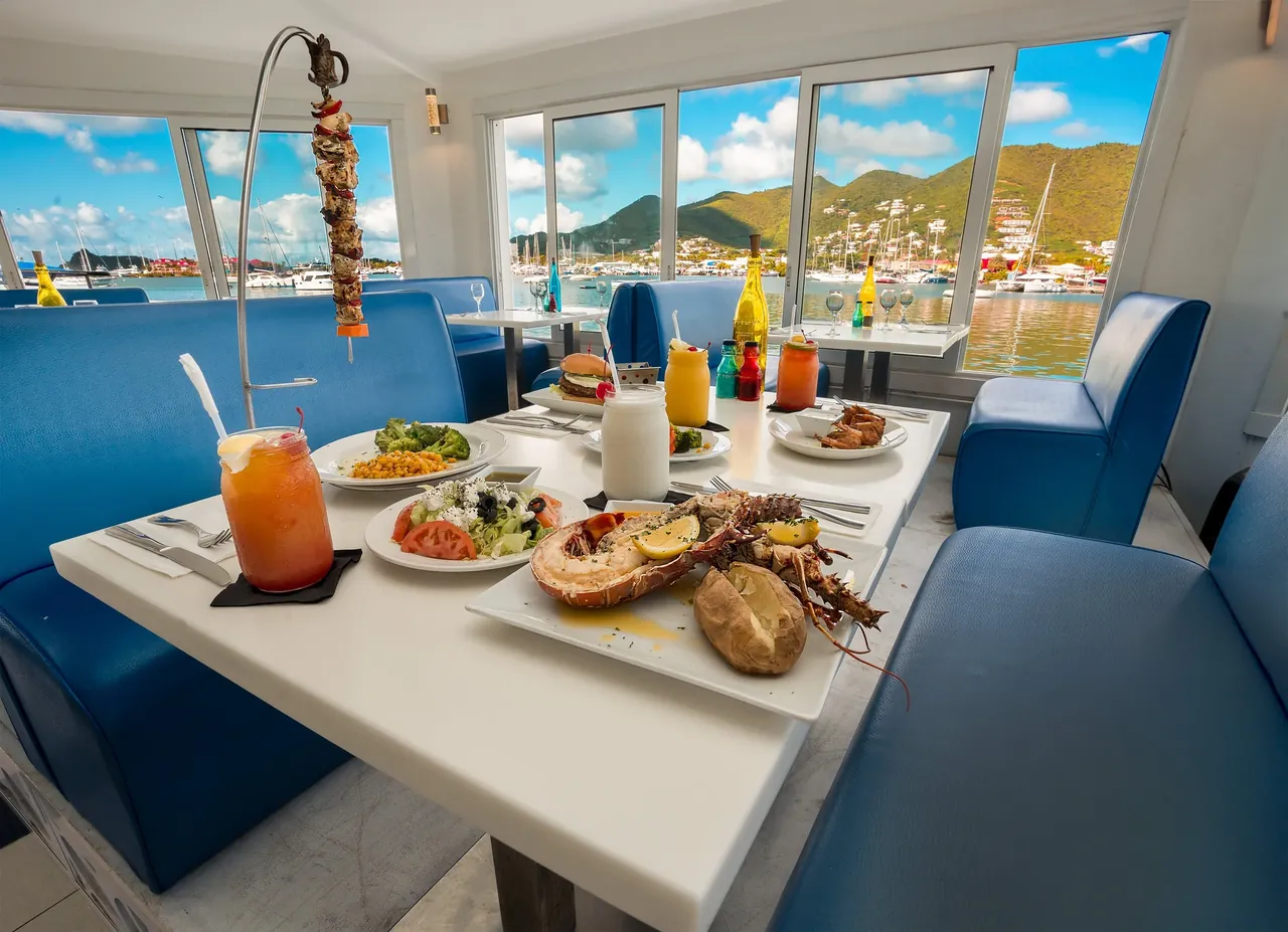 Salle de Topper's avec banquettes bleues et carreaux italiens donnant sur le lagon