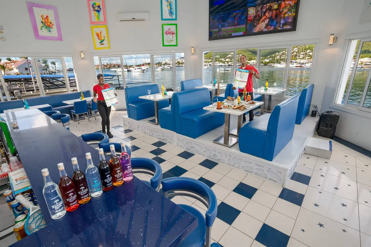 Vue de la salle à manger de Topper's avec tables dressées face aux yachts amarrés
