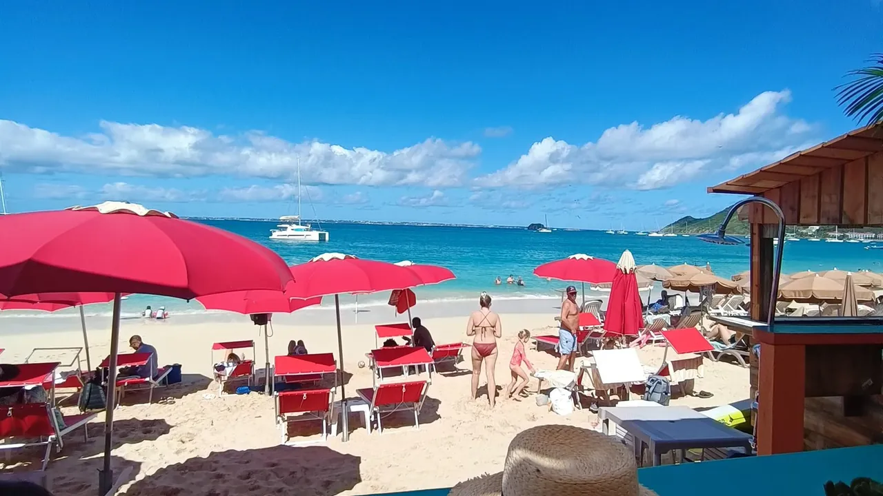 Tropic's Beach Bar SXM - Parasols rouges et transats sur la plage de Grand Case