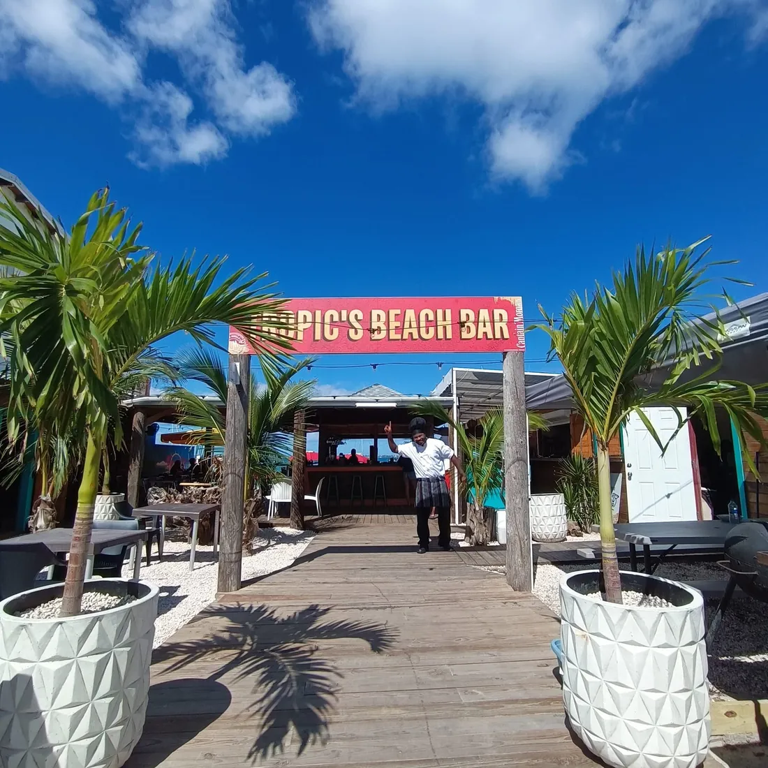 Tropic's Beach Bar SXM - Entrée avec enseigne et palmiers sur le boulevard de Grand Case