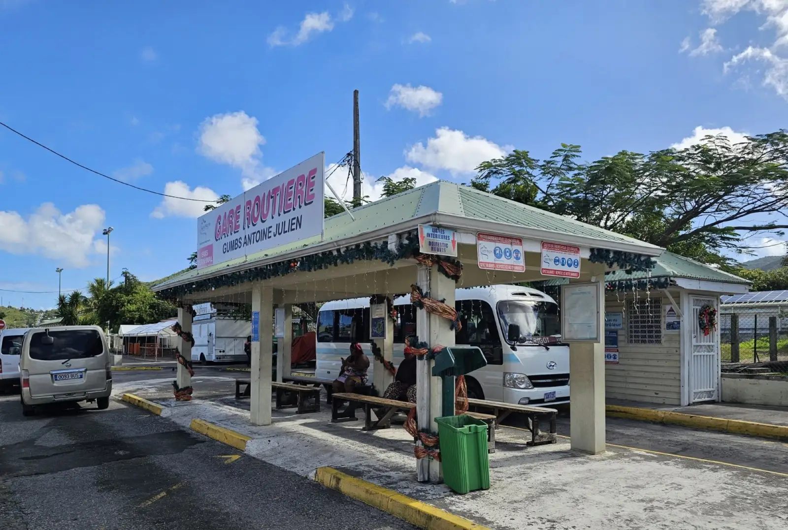 La gare routière Gumbs Antoine Julien à Marigot, ses bancs couverts et un minibus en partance