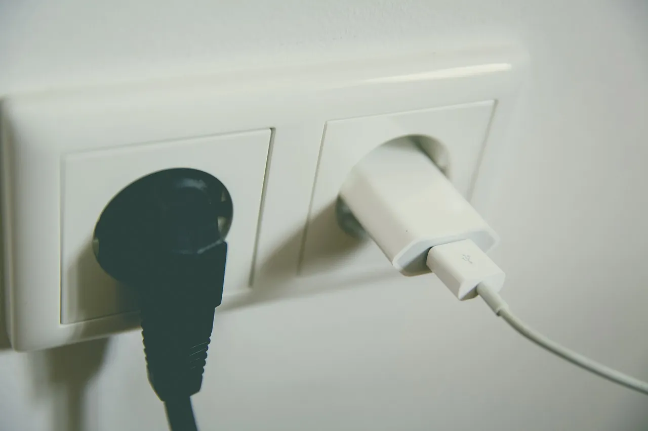 Prise murale européenne double avec une fiche et un chargeur branchés, comme côté français