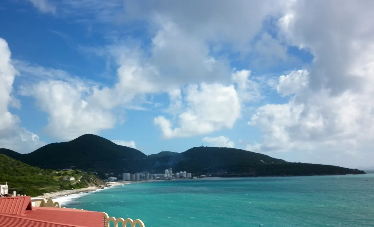 Vue sur Pelican Key Beach devant Flamingo Beach Resort avec mer turquoise et collines de Cole Bay