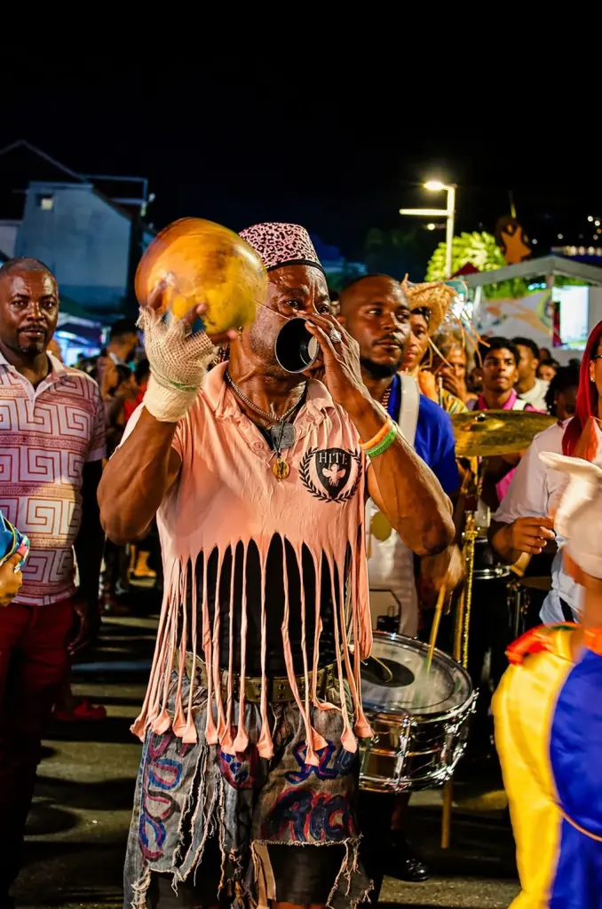 Carnival musician playing a conch shell at Grand Case Tuesdays