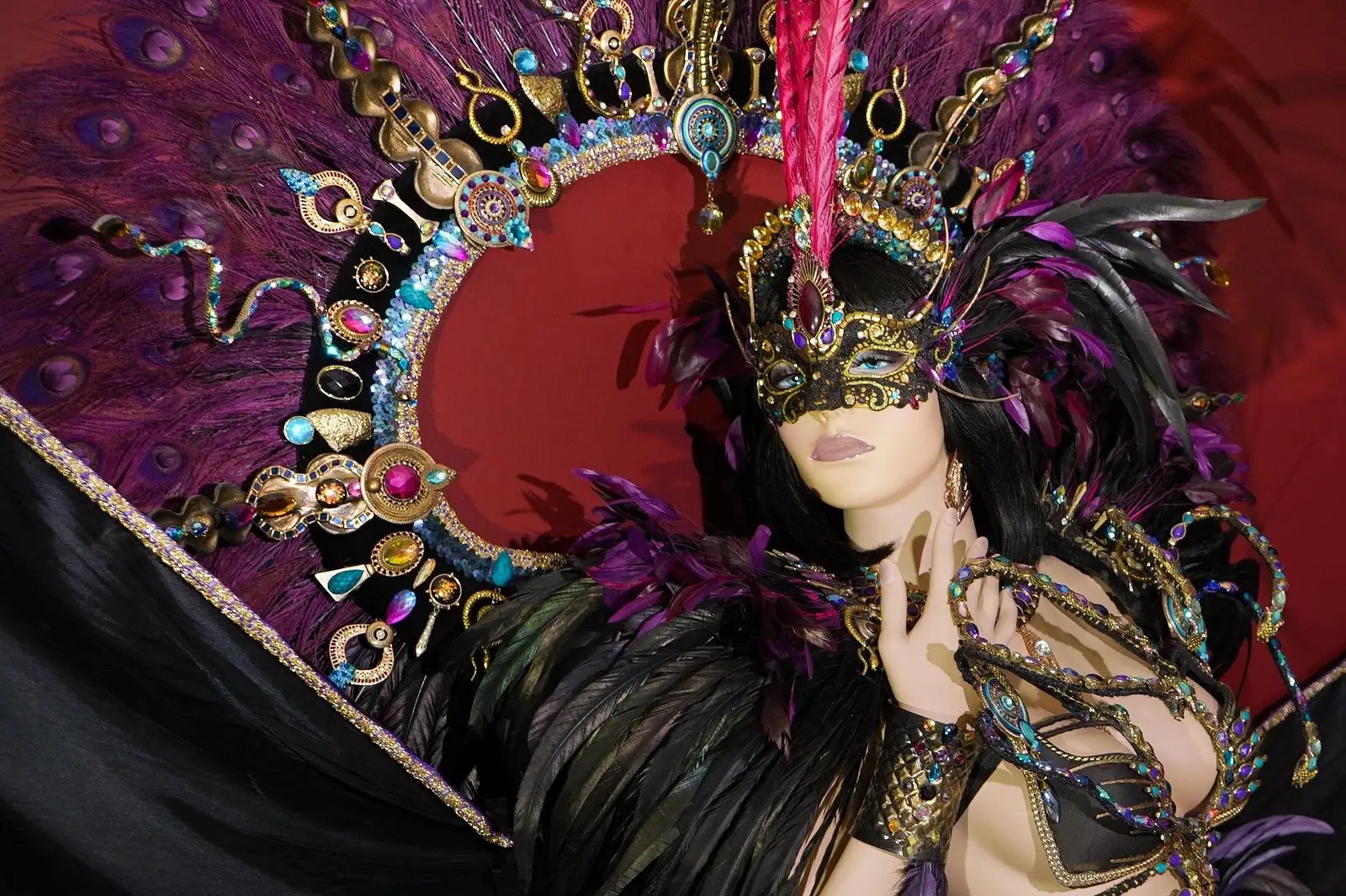 Costume de carnaval à plumes violettes et masque doré exposé au musée We Culture à Maho